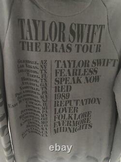 TAYLOR SWIFT Eras Tour Concert Black Hooded Sweatshirt Medium translates to 'TAYLOR SWIFT Sweatshirt à capuche noire de taille moyenne pour la tournée Eras Concert'.